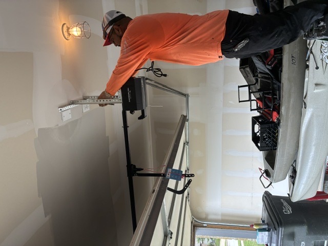 Garage door opener technician working inside a New Braunfels garage